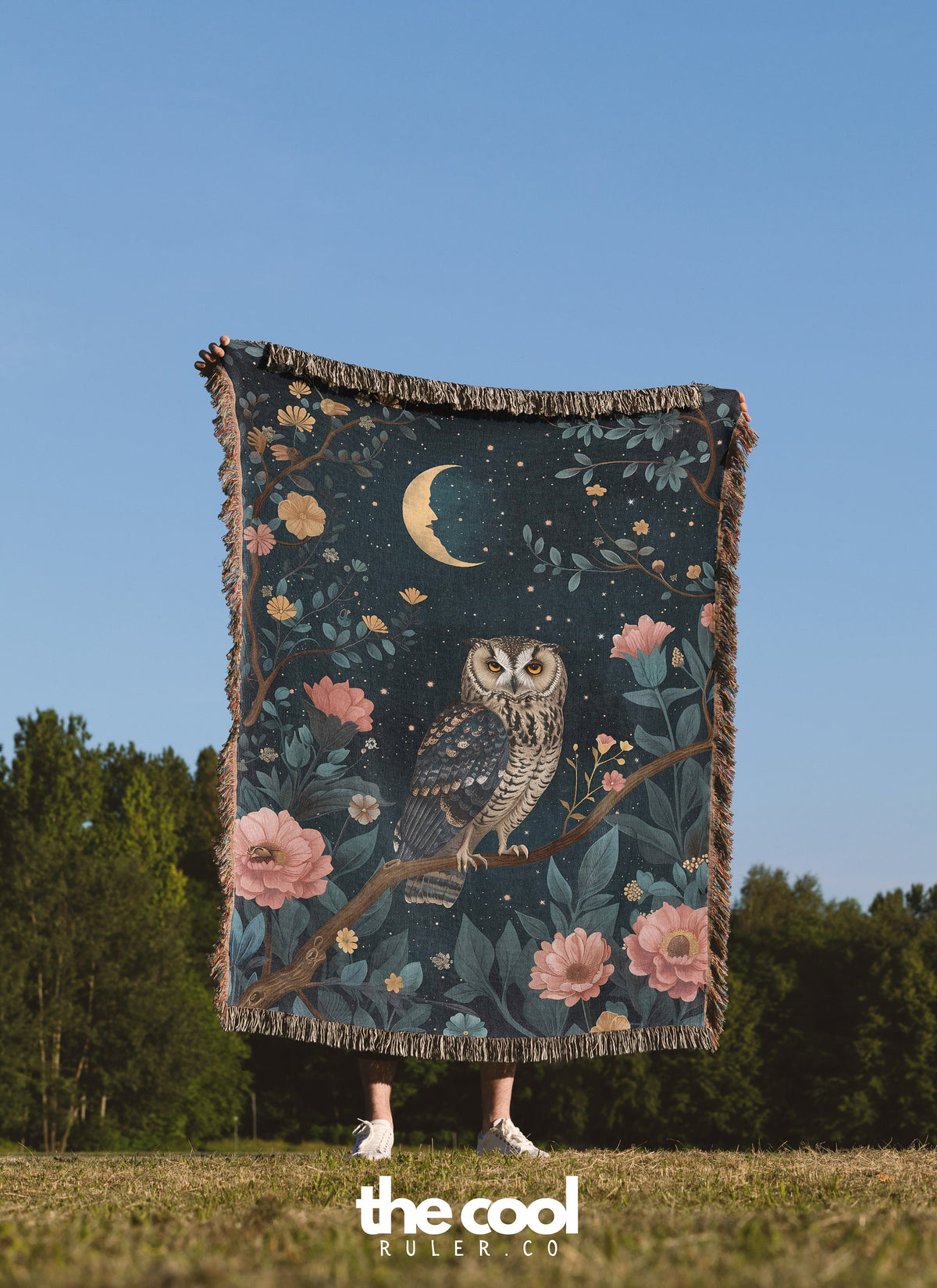 a woman holding a blanket with an owl on it