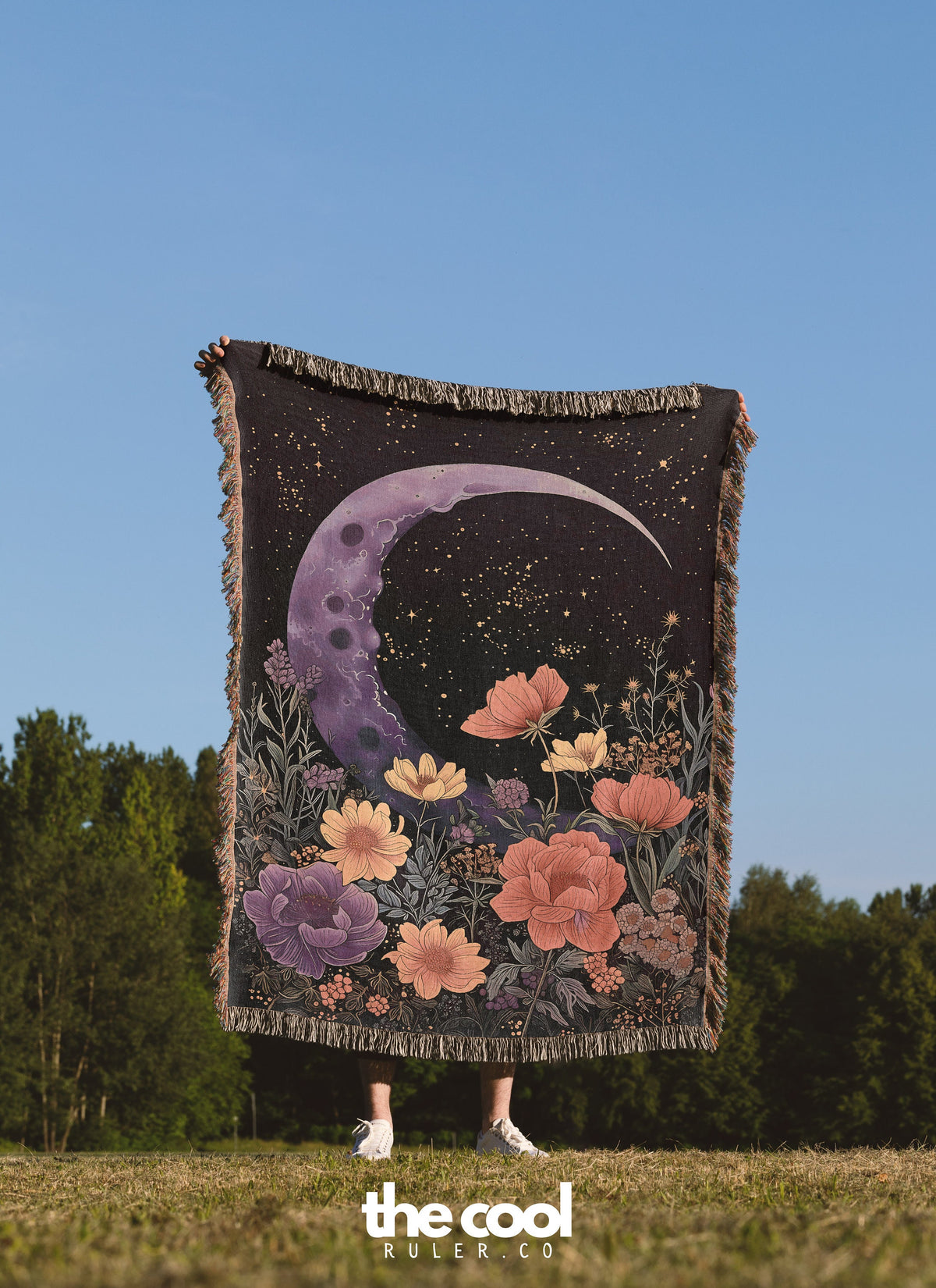 a woman standing in a field holding a blanket