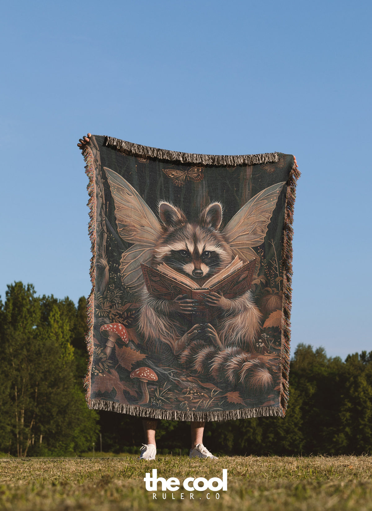 a woman holding a large tapestry of a raccoon