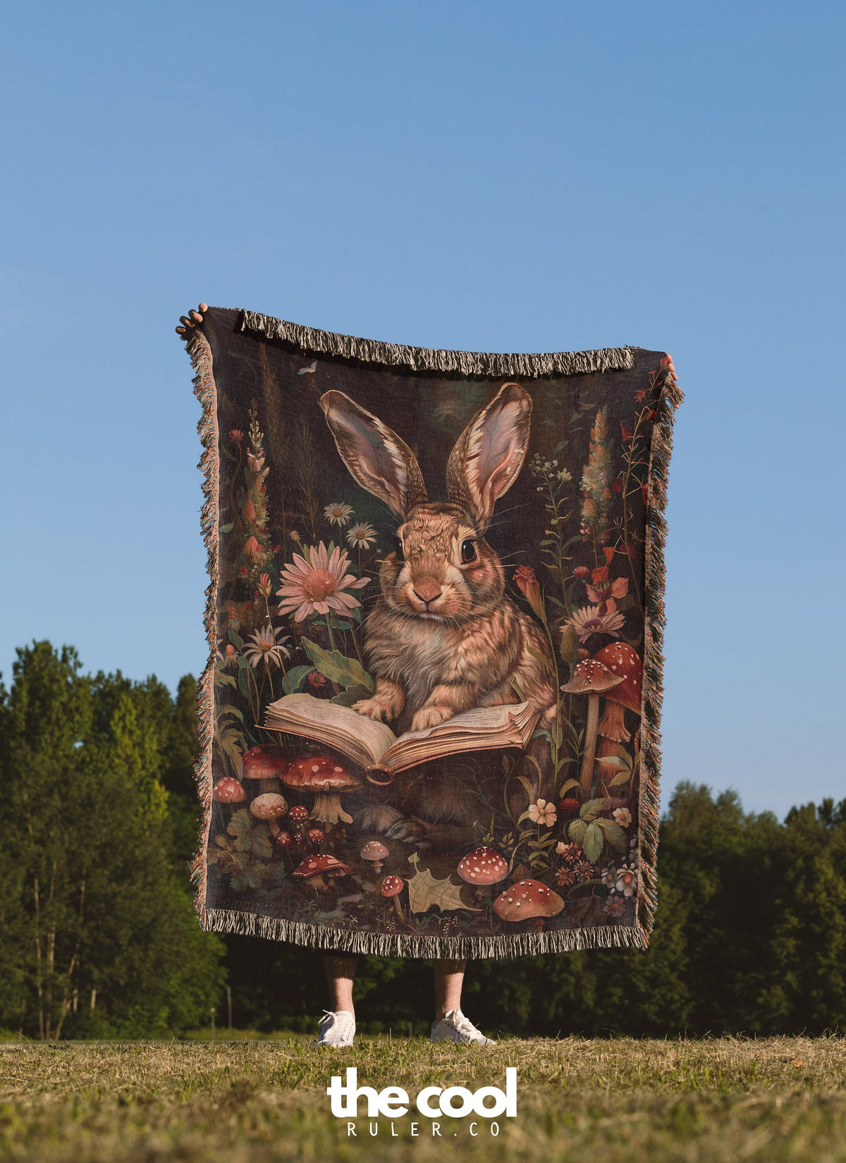 a woman holding a tapestry of a rabbit reading a book
