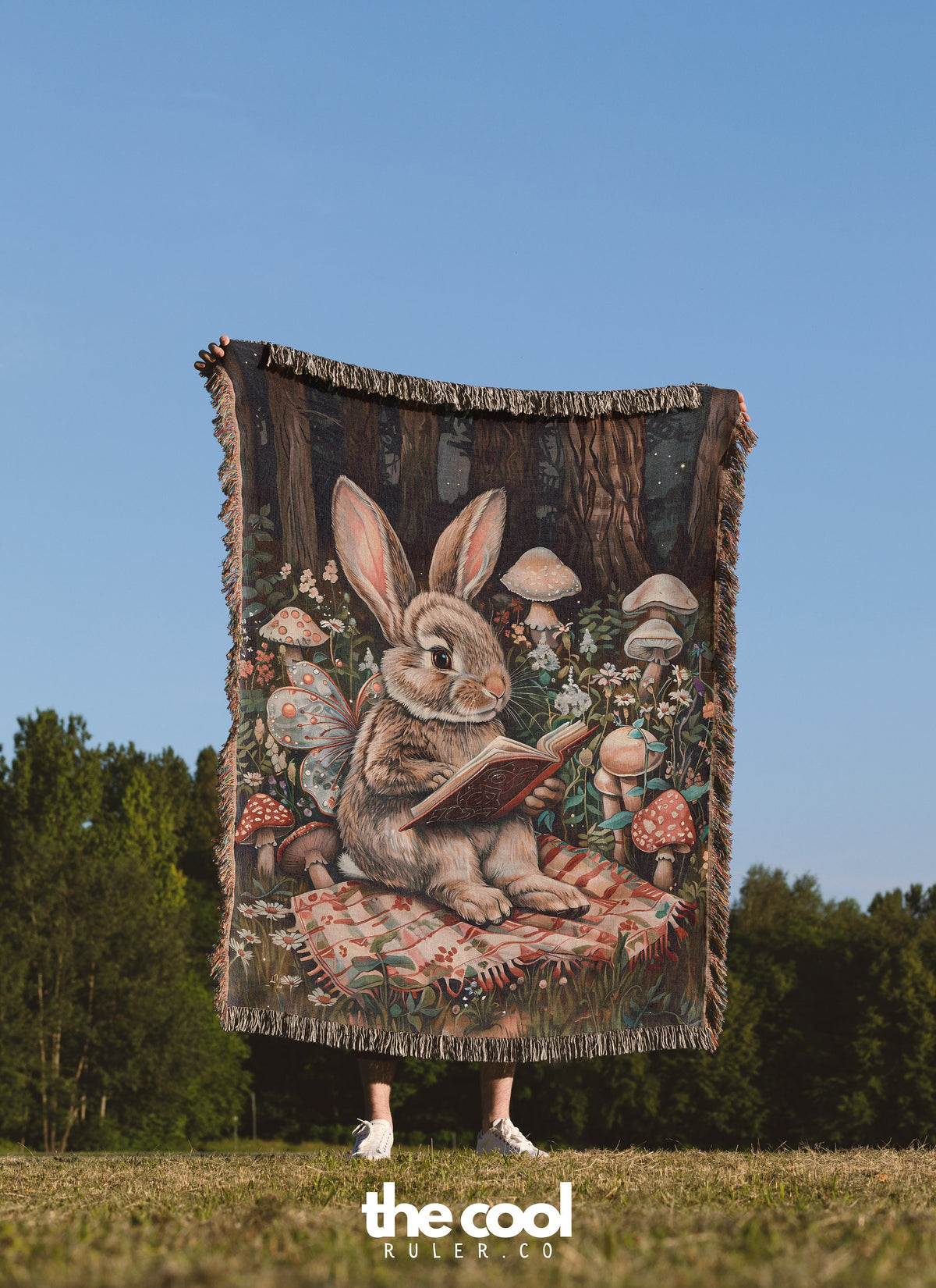 a woman standing in a field holding a tapestry