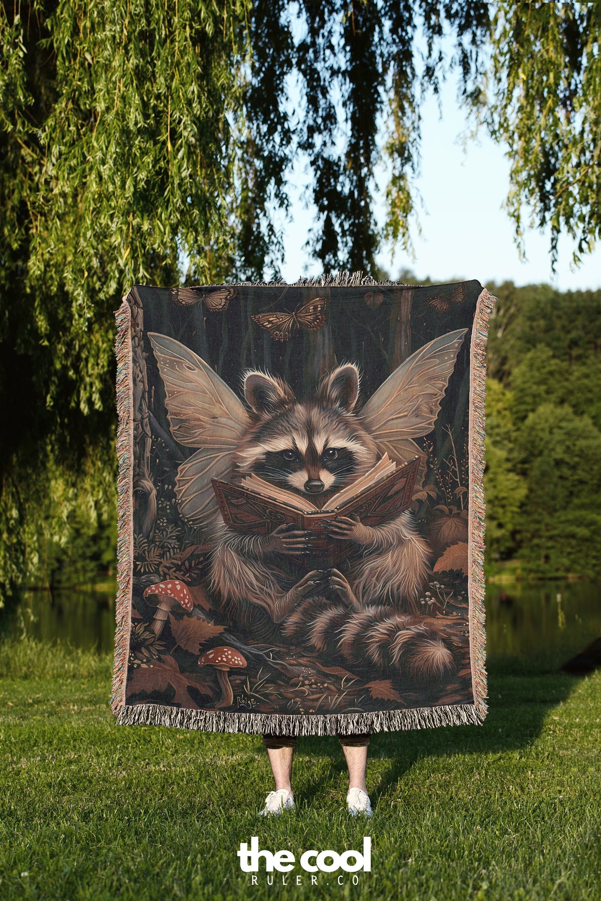 a raccoon is holding a blanket in the grass