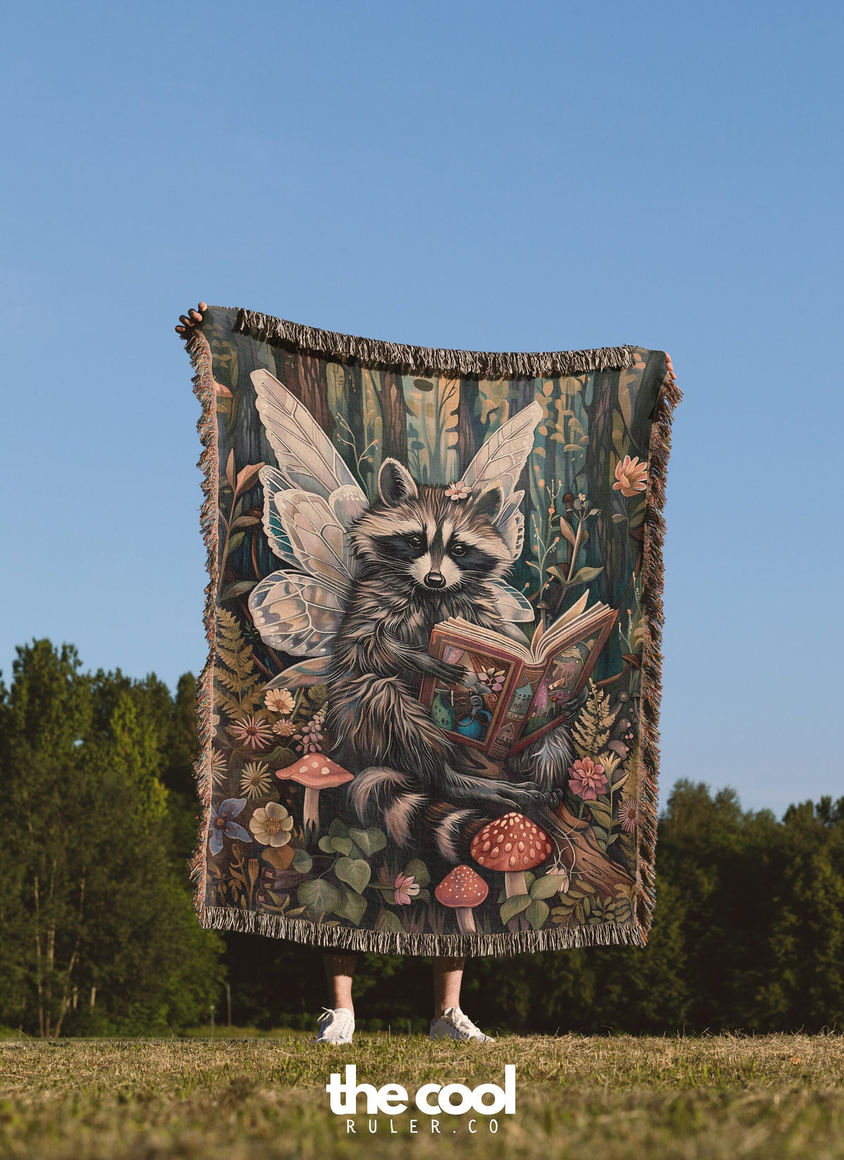 a raccoon holding a book in a field