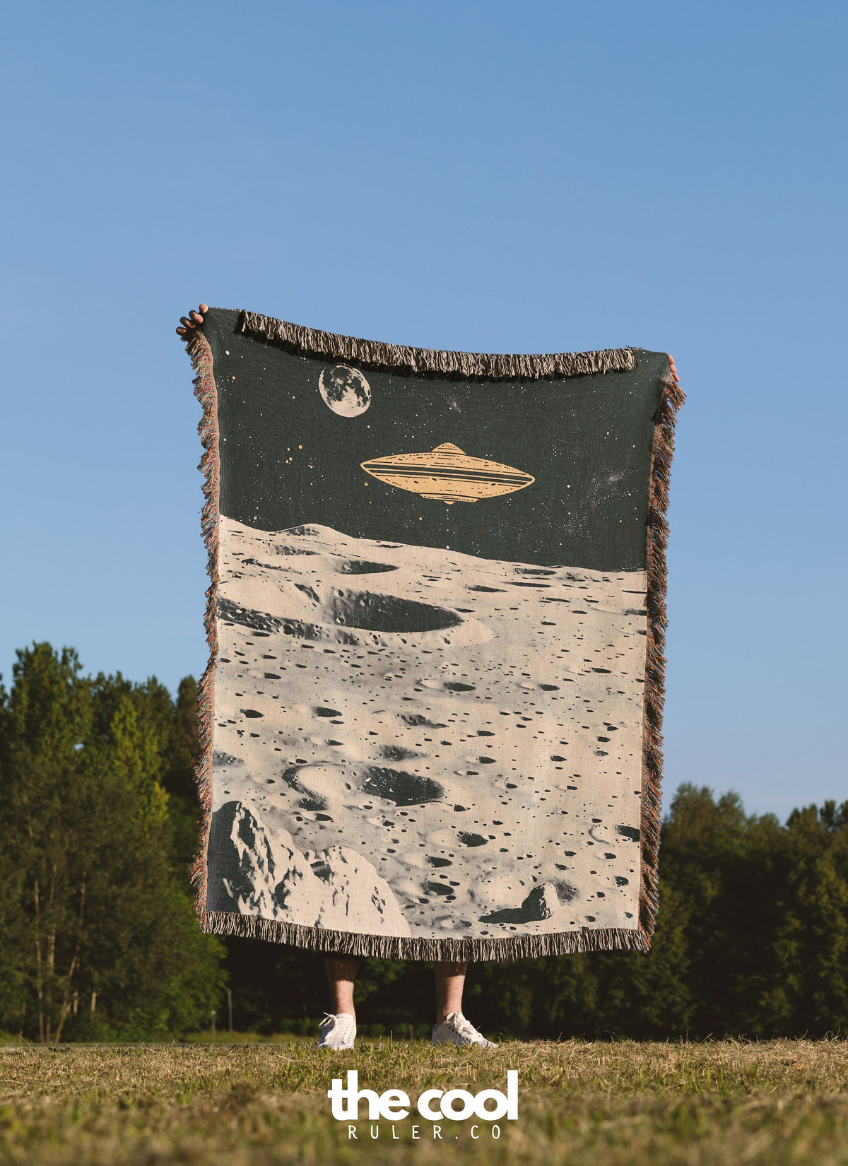 a person standing in a field holding a large blanket
