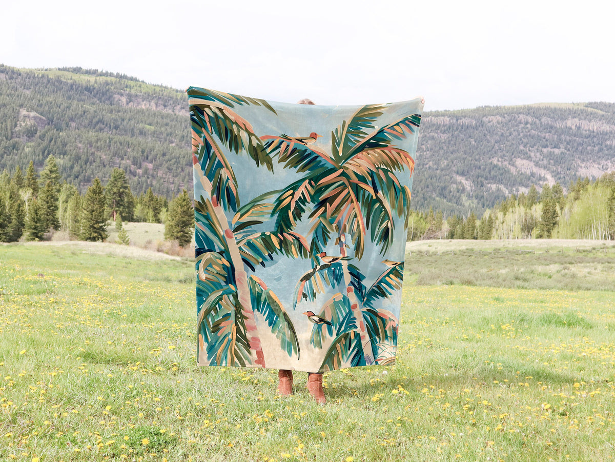 a blanket that has a picture of a palm tree on it