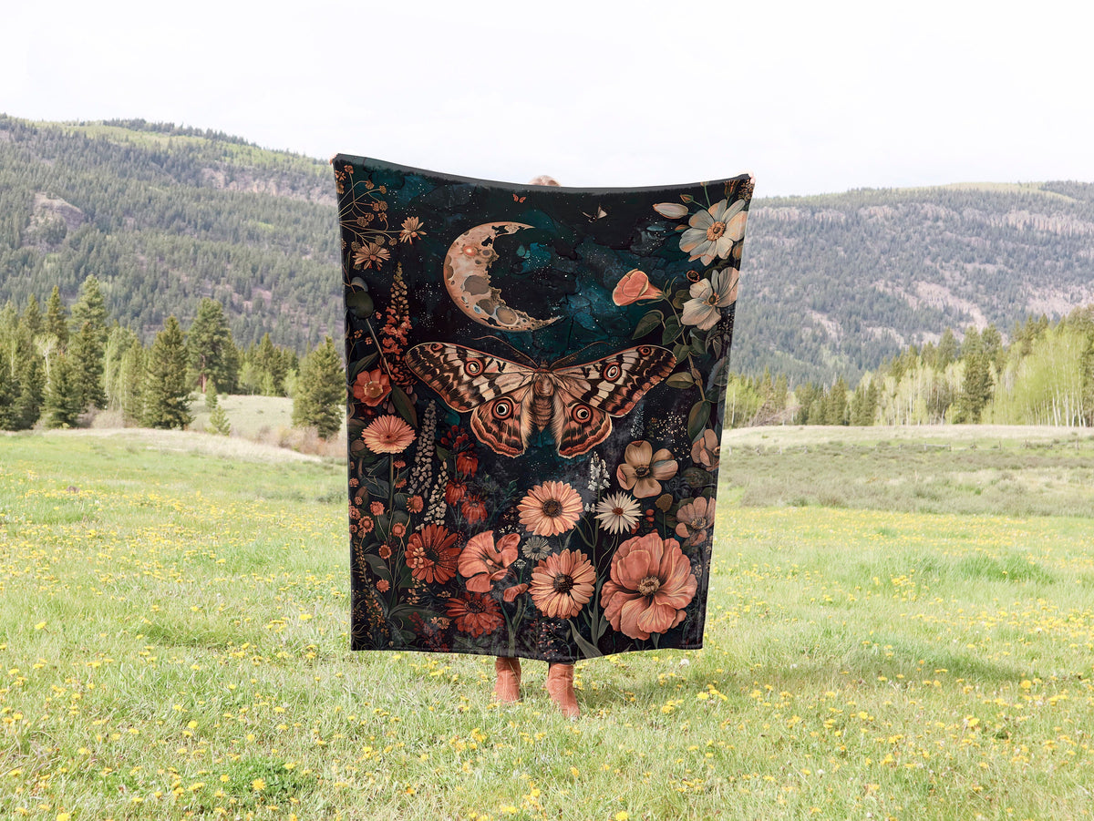 a woman standing in a field holding a blanket