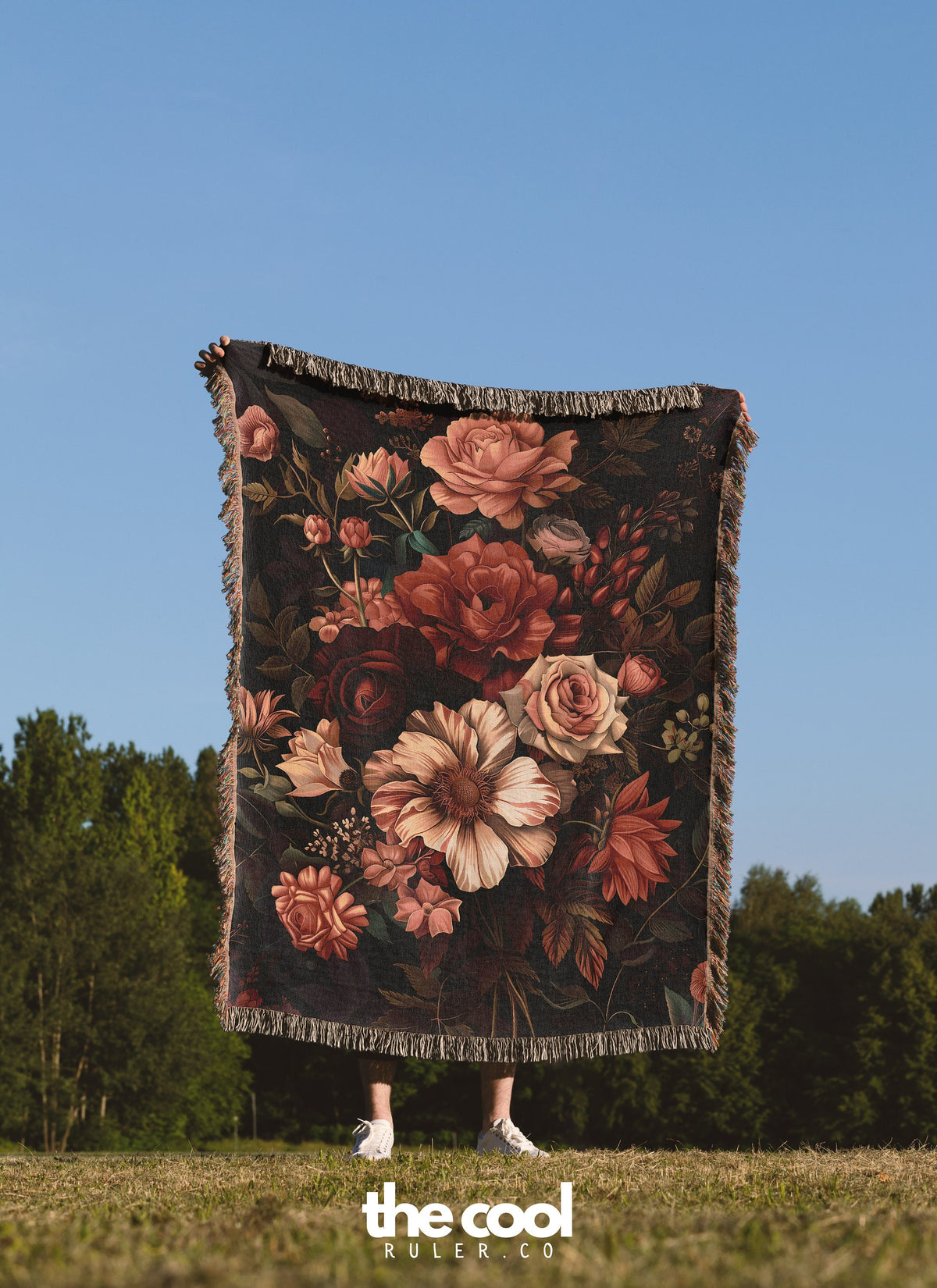 a woman standing in a field holding a blanket