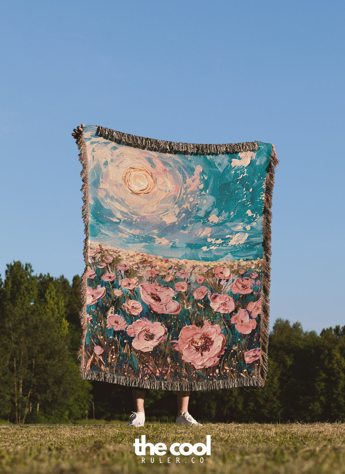 a woman standing in a field holding a blanket