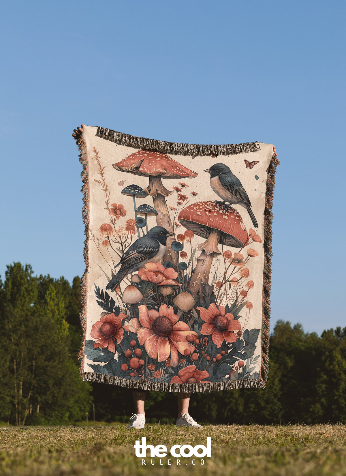 a woman standing in a field holding a tapestry