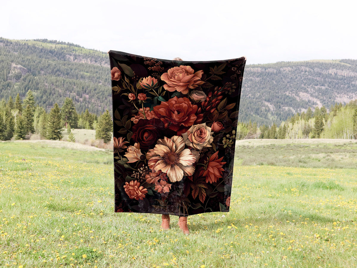 a blanket with flowers on it in a field