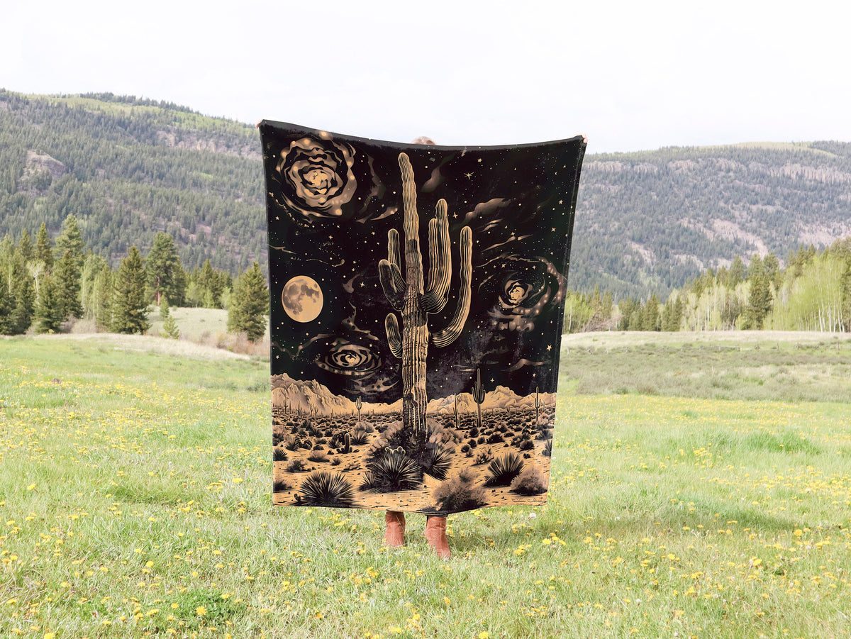 a blanket with a cactus on it in a field