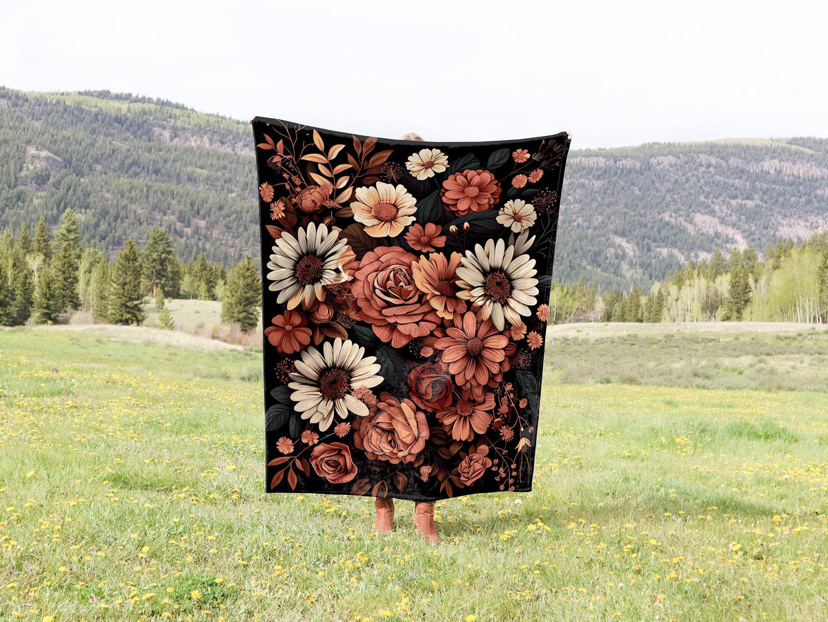 a woman holding a blanket with flowers on it