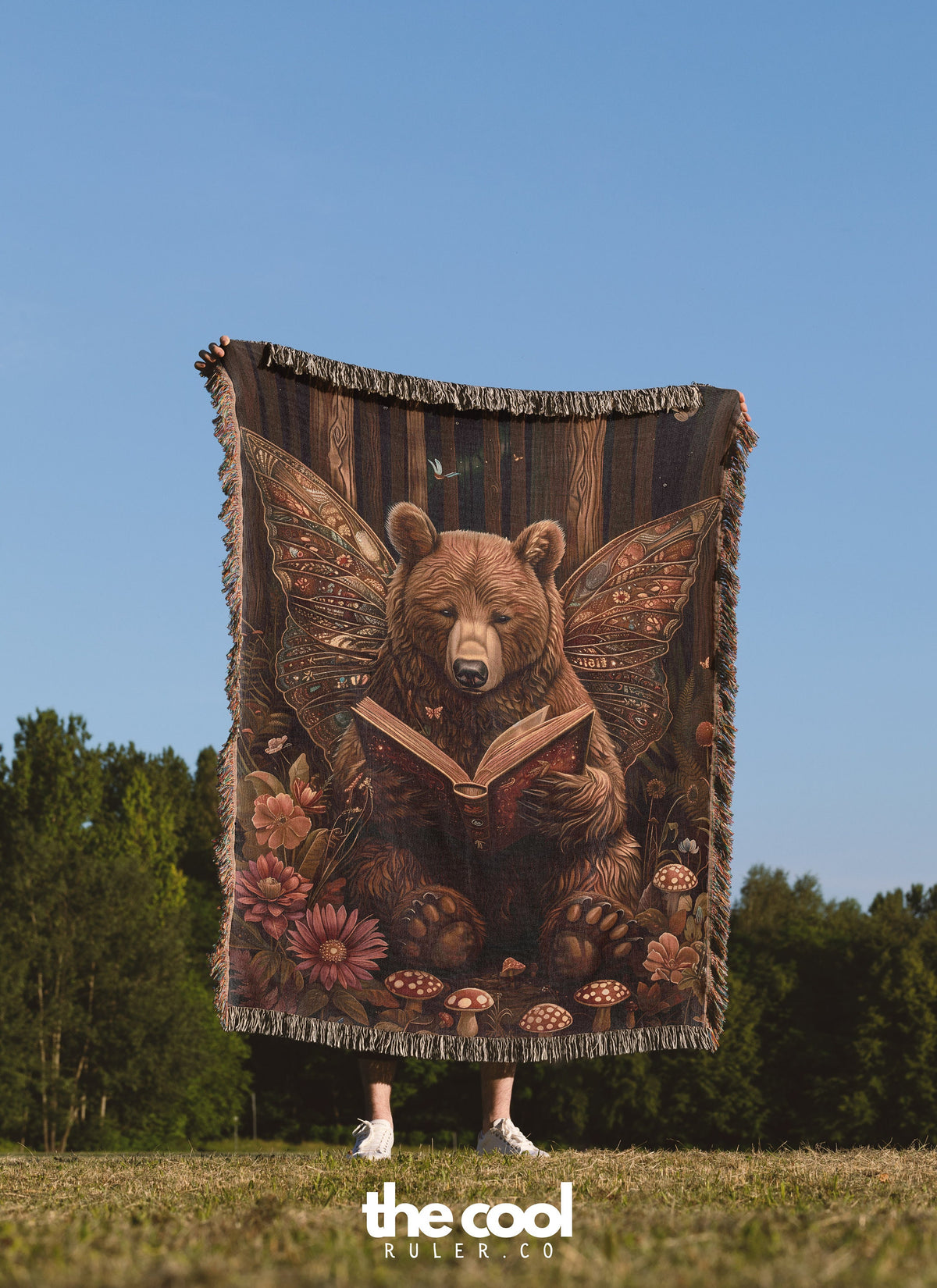 a bear is reading a book on a blanket