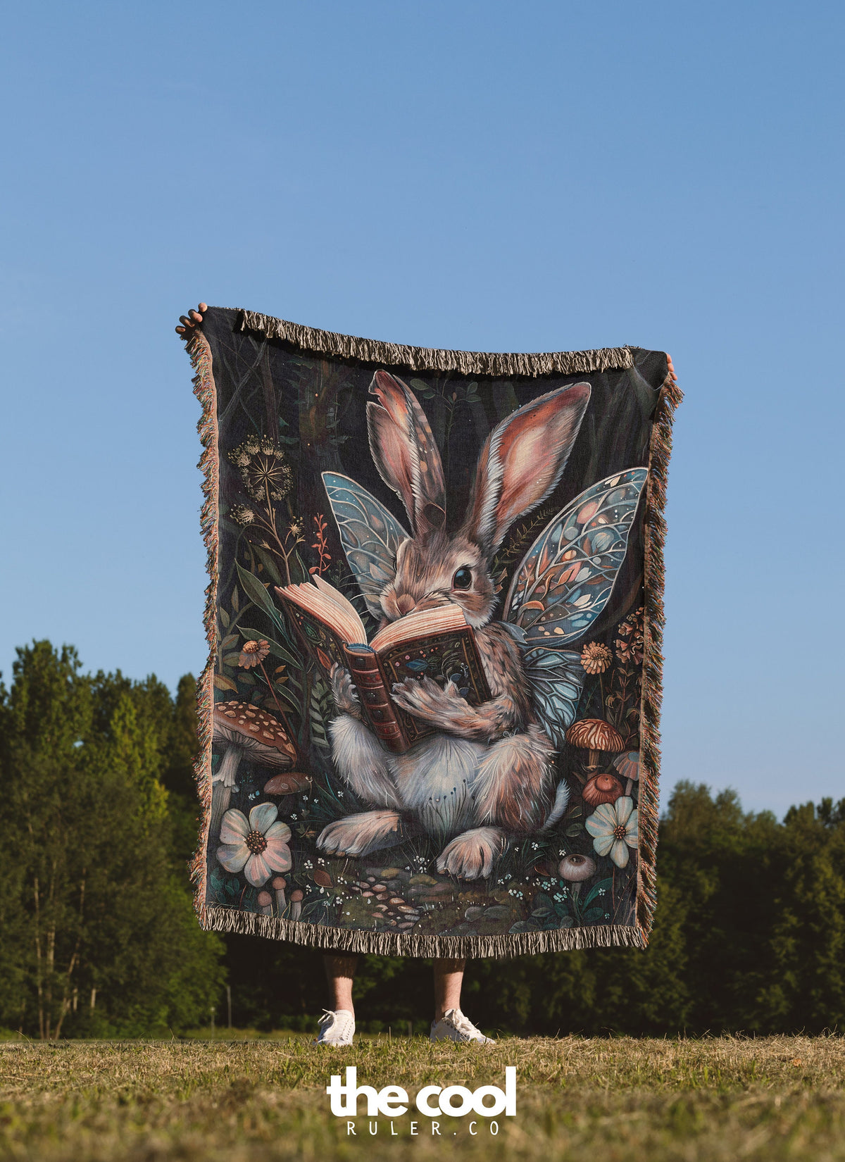 a woman holding a blanket with a picture of a bunny reading a book