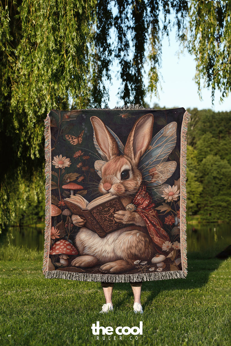 a rabbit is sitting on a blanket in the grass