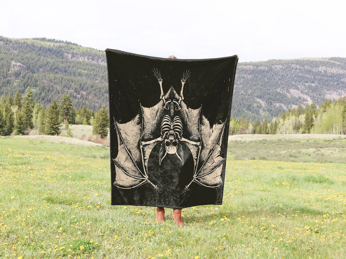 a person standing in a field holding a black and white bat towel