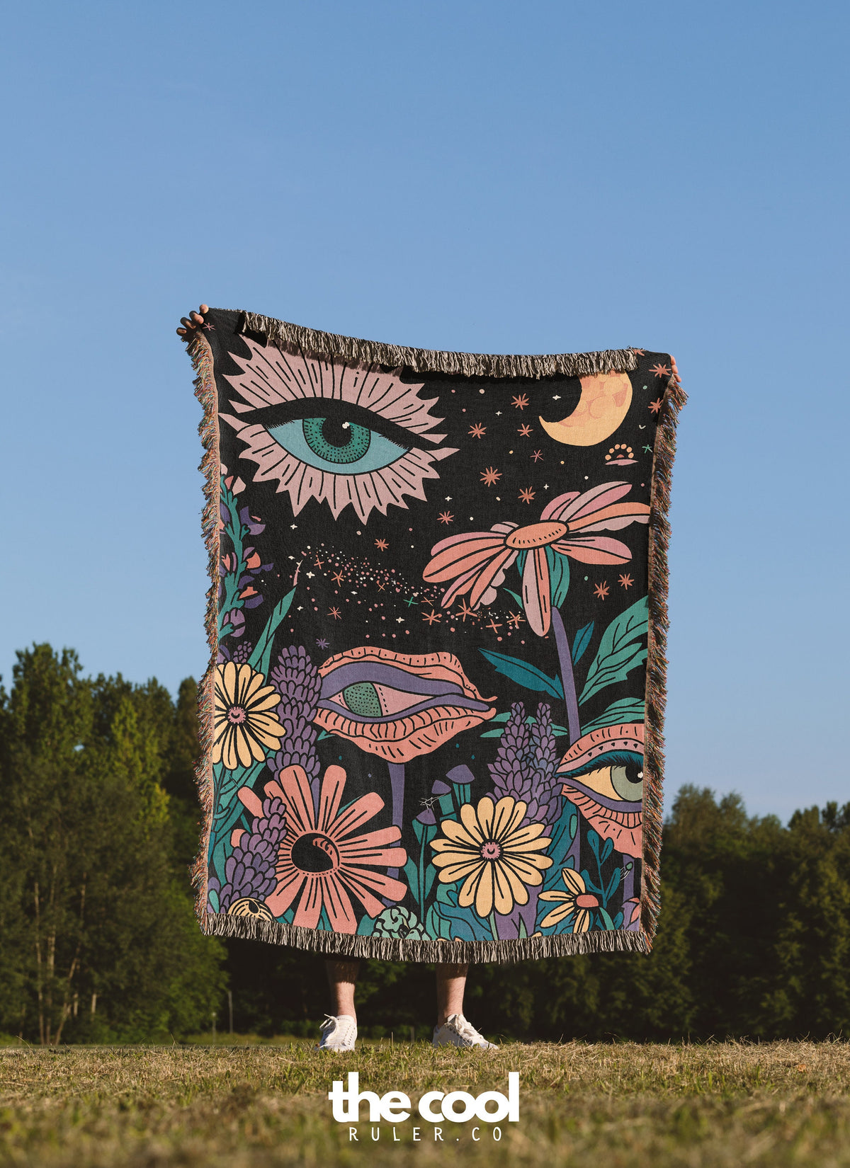 a woman standing in a field holding a blanket