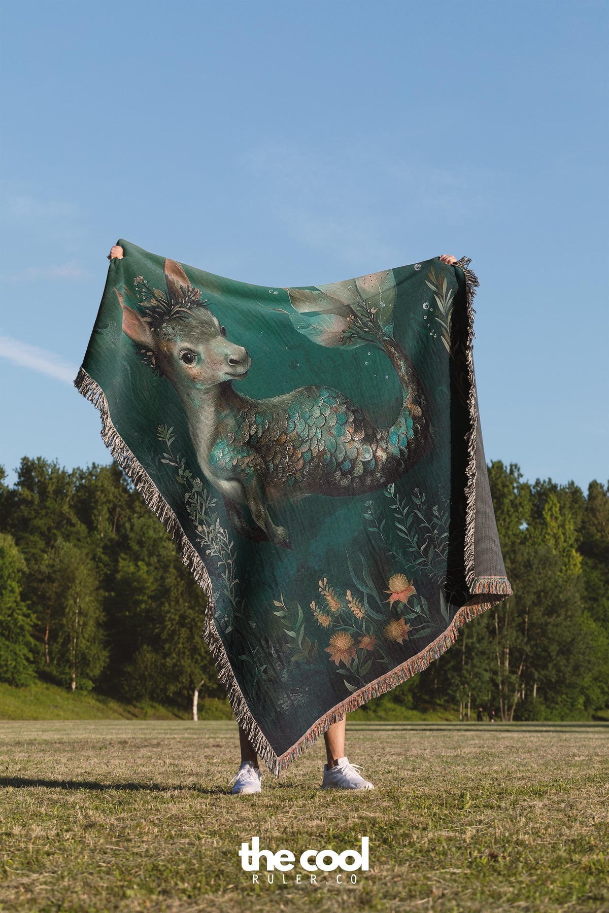 a woman standing in a field holding a blanket