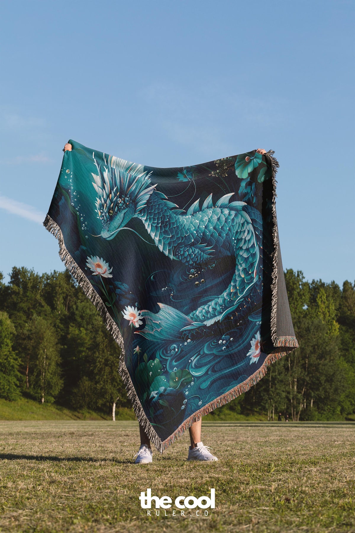 a woman standing in a field holding a blanket