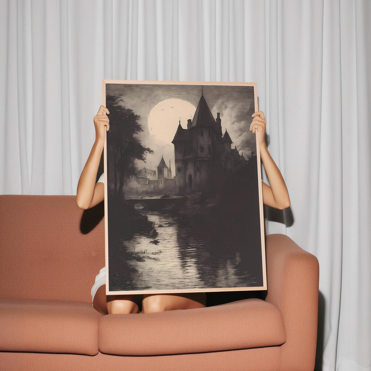 a woman sitting on a couch holding up a painting