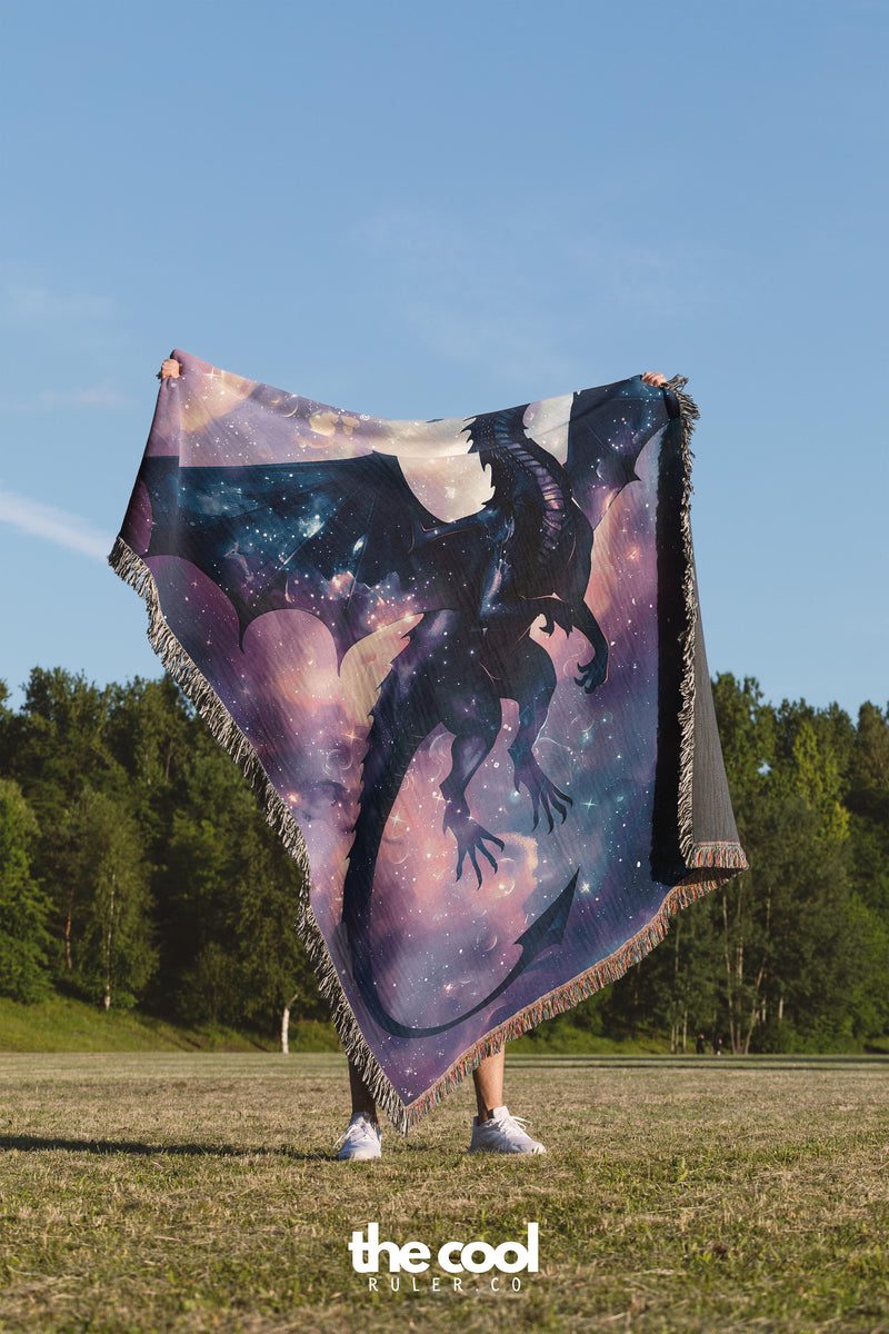 a woman is holding a blanket with a picture of a dragon on it