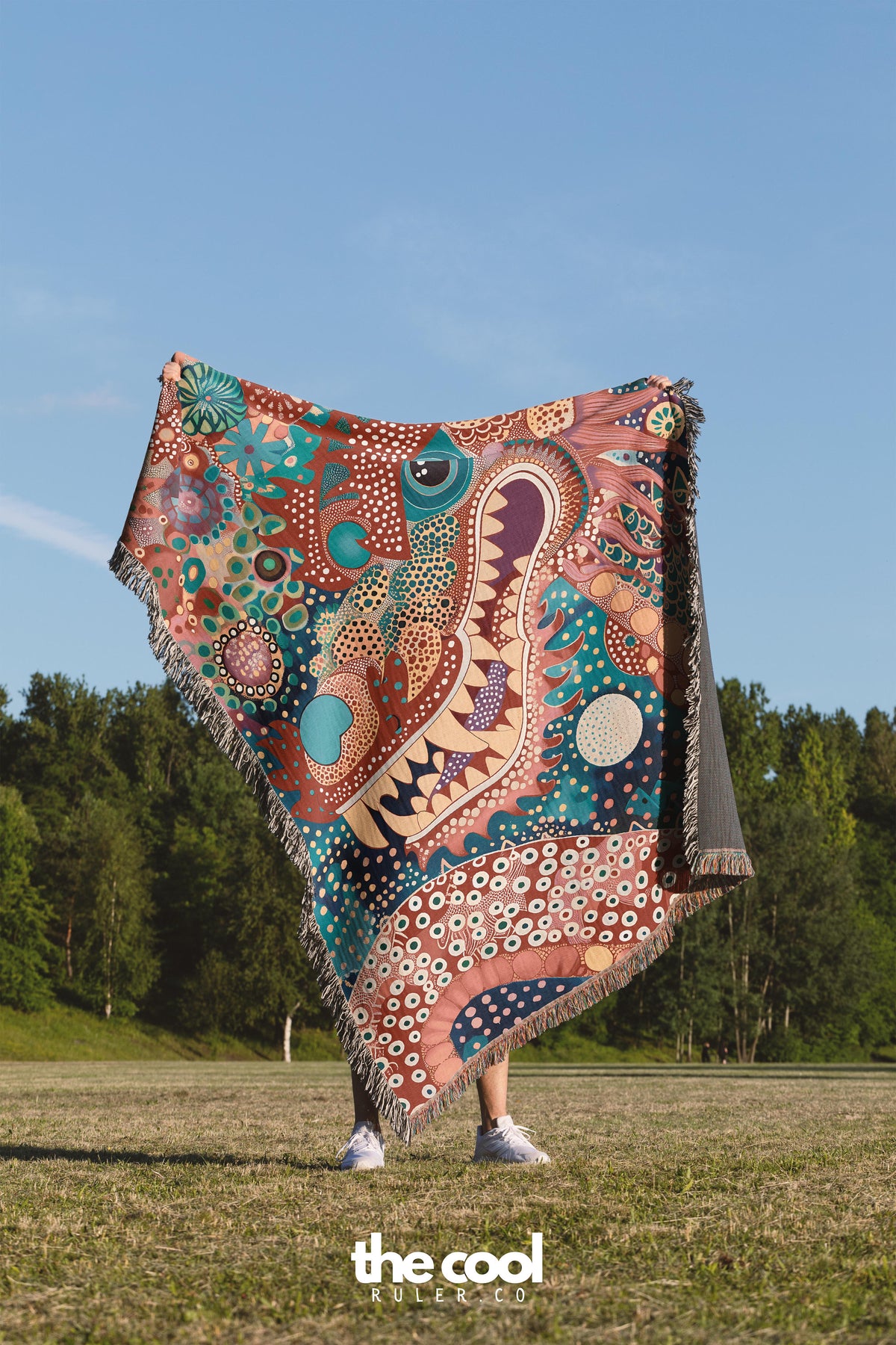 a person standing in a field holding a colorful blanket