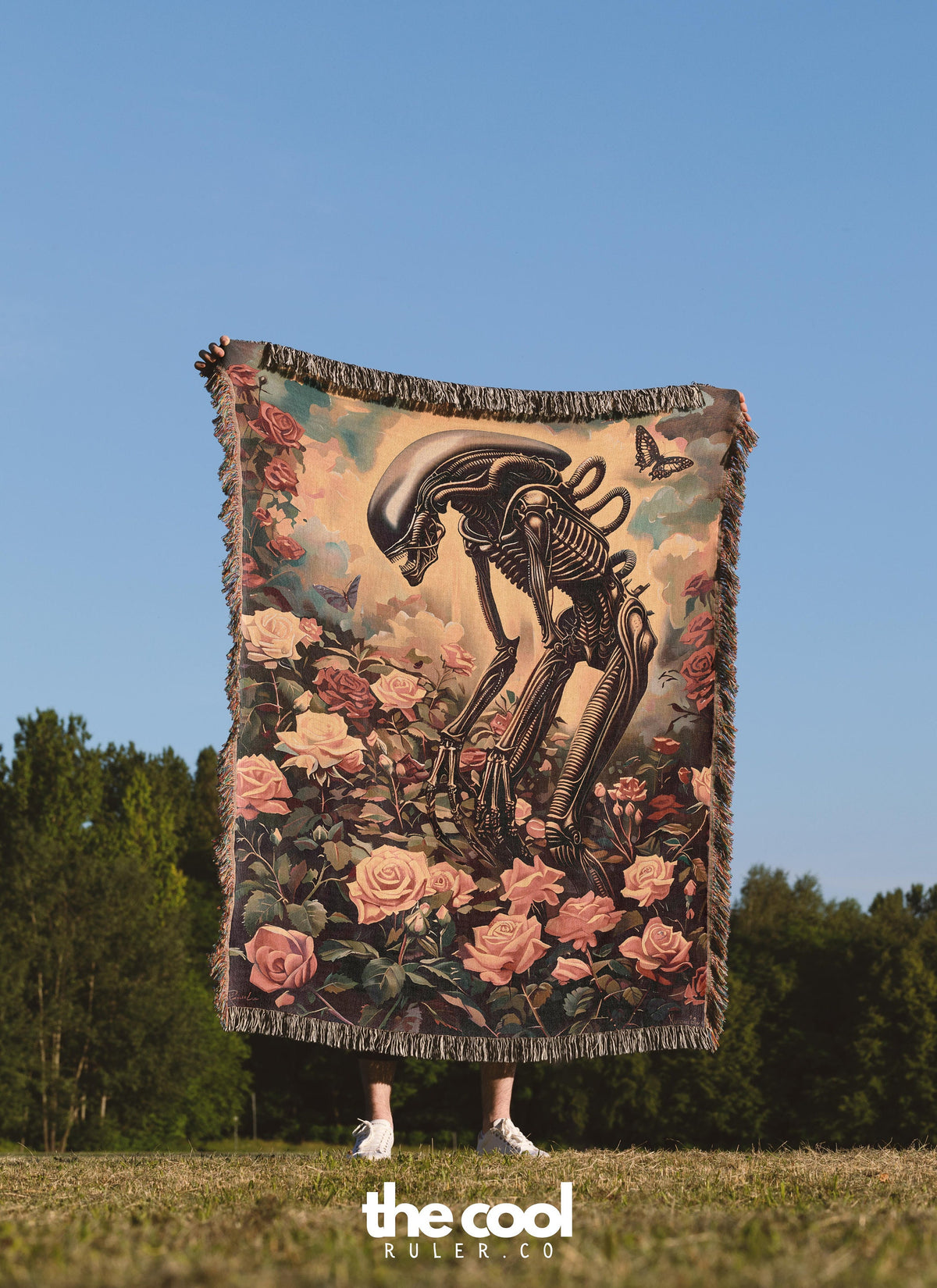 a person standing in a field holding a large tapestry